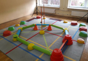 sala zabaw ruchowych z dywanem do zabaw tanecznych i urządzeniami do toru przedszkód